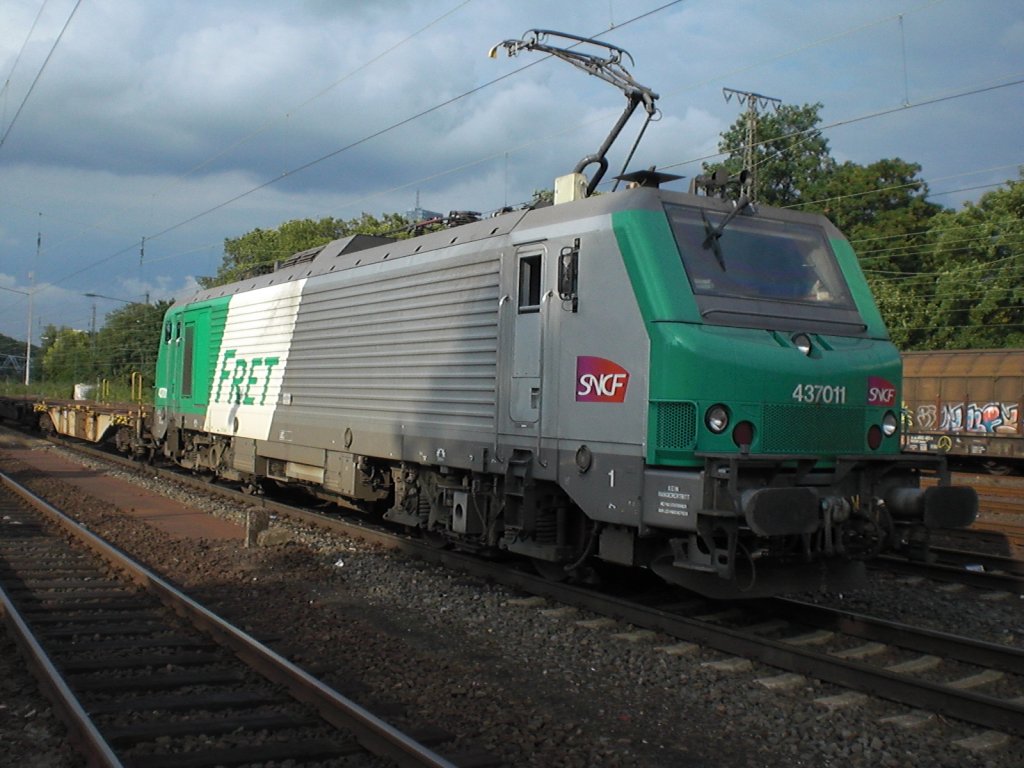 Br.437011 von der SNCF in Kln-West vor einem leeren Containerzug.